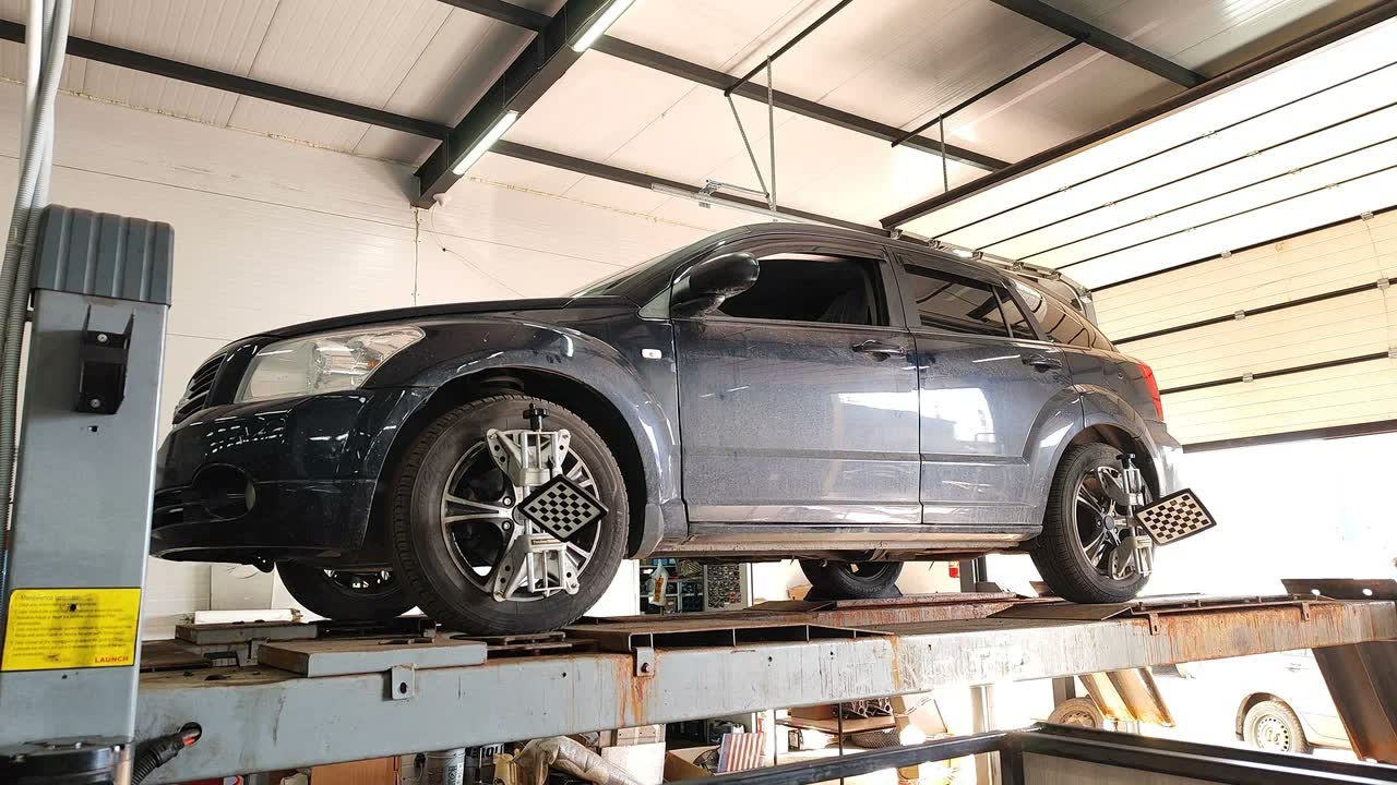 Автомобиль на 3D-стенде сход-развала с измерительными мишенями на колёсах
